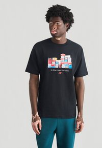 Μαύρο βαμβακερό t-shirt με γραφικό στοιχείο από στοίβα πολύχρωμων κουτιών παπουτσιών, με το κείμενο «Το σημαντικό είναι το εσωτερικό» από κάτω.