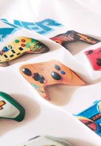 Grafik af forskellige farverige spillecontrollere på en hvid baggrund med unikke designs, knapper og teksturer i levende farver.