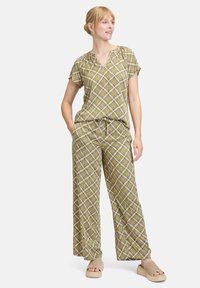 Twee-delig set met een kortelijfs top en wijde broek in een groen en roze geometrisch patroon, gemaakt van lichtgewicht stof.