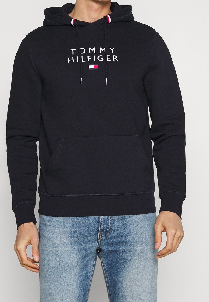 Sudadera azul marino con capucha ajustable, bolsillo frontal y logo impreso en blanco "TOMMY HILFIGER". Tejido de mezcla de algodón, diseño de ajuste regular.