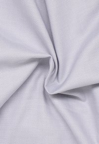 Hellgrauer_texturierter_stoff_mit_einem_subtilen_geometrischen_Muster,_das_eine_glatte_Oberfläche_und_einen_weichen_Fall_zeigt._Perfekt_für_Bekleidung_oder_Möbelpolsterung.