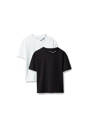 Deux t-shirts à manches courtes col rond, un blanc et un noir, chacun avec le logo "Calvin Klein" imprimé près du col.