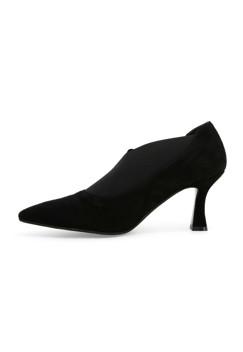 Scarpa con tacco alto in suede nera, con punta affilata e pannello laterale elastico. Il tacco è sottile e presenta un accentuazione metallica.