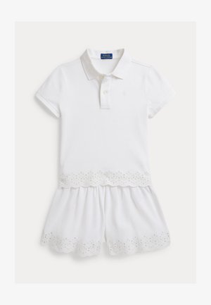 Rochie polo albă cu mâneci scurte, având tiv ondulat și detalii cu ochiuri la fustă. Fabricată dintr-un material de bumbac respirabil.