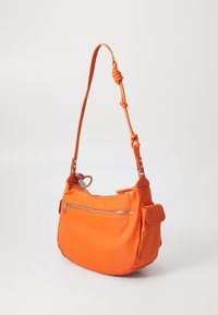 Pomarańczowa nylonowa torba na ramię z zamykaną na zamek przednią kieszenią, regulowanym paskiem i węzełkowym akcentem na uchwycie. Gładka tekstura o miękkim kształcie.