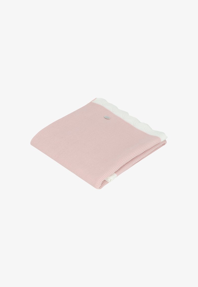 Tela de punto rosa con un borde blanco en forma de concha y un pequeño emblema decorativo. Doblada cuidadosamente, mostrando la textura y el contraste de color.