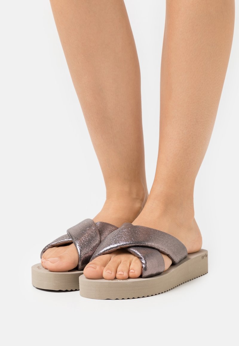 Sandales glissantes en bronze pailleté avec un design de lanière entrecroisée et une semelle épaisse beige, présentant un fond texturé pour une meilleure adhérence.