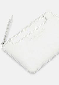 Biała skórzana etui na karty z zapięciem na zamek, wytłoczonym logo marki i przeszyciami. Posiada slot na karty z jednej strony.