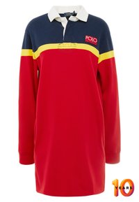 Pikétröja med röd kropp, marin- och gula ränder, vit krage, långa ärmar och en logotyp på bröstet.