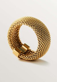Brazalete de malla dorada con forma cilíndrica, que presenta una textura suave y brillante, además de un detalle de cierre minimalista.