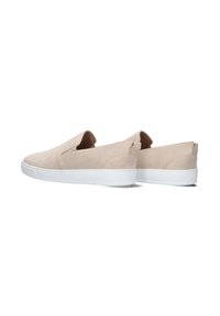 Beige instapschoenen van suede, met een witte rubbere zool, strakke lijnen en een minimalistisch ontwerp zonder zichtbare veters of hardware.