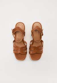 Bruine leren sandalen met drie horizontale banden en een enkelgesp. Ronde neus, platte zool met gevlochten randafwerking.