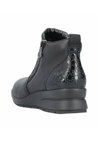 Bottes noires à la cheville avec une tige en cuir lisse, accent en cuir serpent brillant, fermeture à glissière et semelle en caoutchouc texturée.