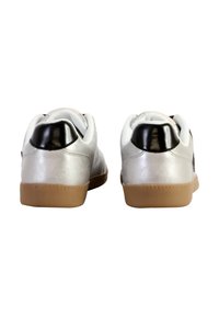 Sneaker sintetiche argento con accenti neri sul tallone, lacci bianchi e suola in gomma naturale. Presentano una texture liscia e un design arrotondato.