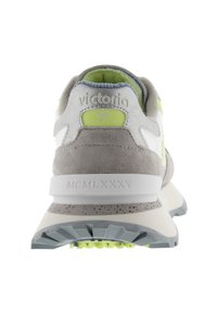 Gray suede and mesh athletic shoe with white accents. Heel features a green logo and "MCMLXXXV" engraving. Lightweight rubber sole with traction.
