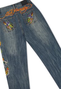 Blue denim jeans with colorful embroidered dragon designs on back pockets and leg, and bright orange "Ed Hardy" stitching on the waistband.