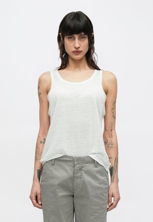 Maieu alb fără mâneci, cu un decolteu rotund și croială ușor lejeră, asortat cu pantaloni gri deschis, având texturi subtile și tatuaje pe brațe.