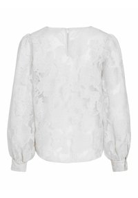 Blouse blanche à manches longues avec broderies florales, poignets boutonnés et petite ouverture en forme de trou de serrure dans le dos.