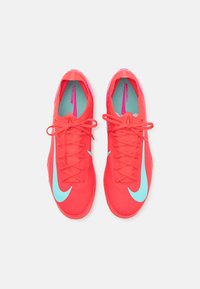 Nike Mercurial football shoes with a bright red upper, blue accents, textured fabric, and a streamlined design. Features lace-up closure.
