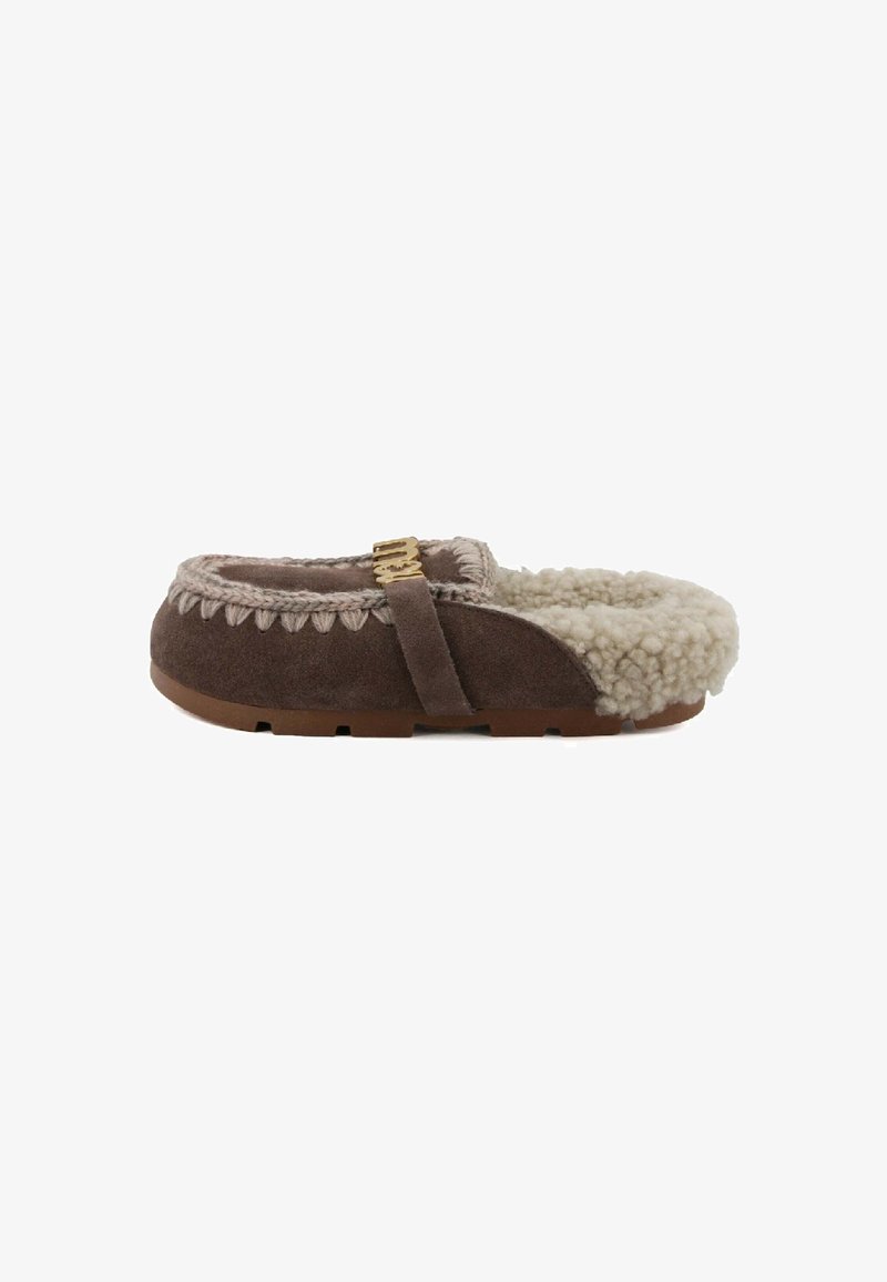 Pantofole in suede marrone con fodera in pelliccia sintetica, dettaglio intrecciato e fibbia dorata. Suola piatta con battistrada testurizzato per aderenza e durata.