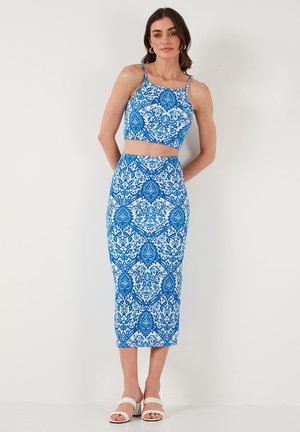 Blauw en wit gestreept twee-delig set bestaande uit een cropped top met dunne banden en een hoog-waisted rok, beide met ingewikkelde ontwerpen.