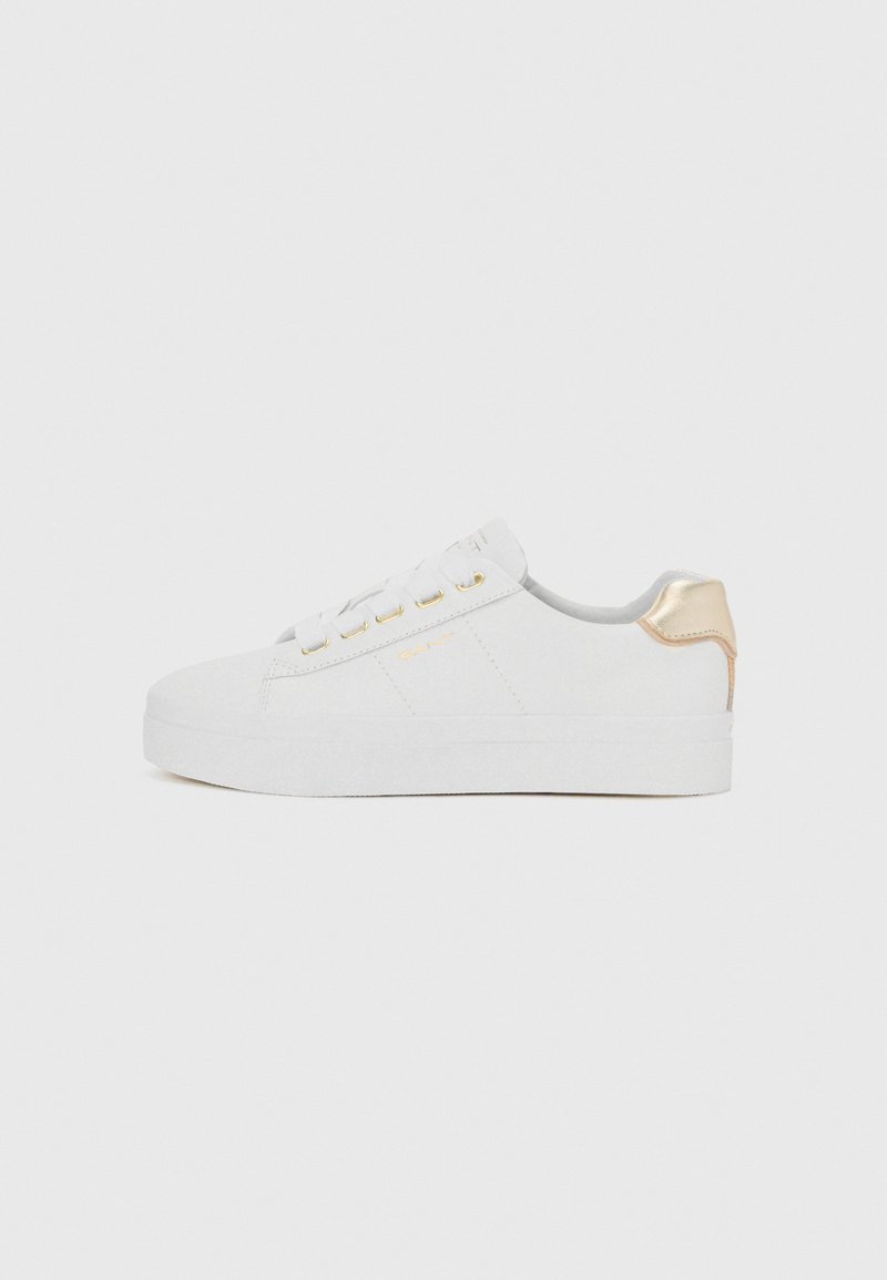 Białe sneakersy z texturedowym zamszowym wykończeniem, płaską podeszwą, złotymi oczkami i złotym akcentem na pięcie. Prosty, minimalistyczny design.