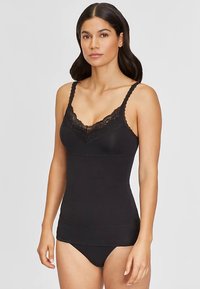 Black camisole with adjustable straps, featuring a lace trim neckline. Smooth fabric, fitted design, and a minimalistic style.