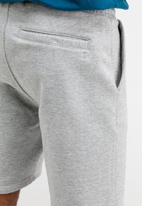 Grijze sweatshorts met een relaxte pasvorm, voorzien van een achterzak en zijinsneden. Gemaakt van zachte, gestructureerde stof voor comfort.