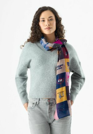 Pull en laine gris clair avec un ourlet côtelé, associé à une écharpe colorée à motif comportant des blocs de texte et des illustrations.