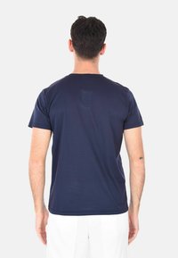 T-shirt a maniche corte blu navy con colletto rotondo e texture liscia; presenta un design minimale con un piccolo dettaglio sul retro.