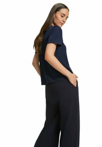 Top corto navy a maniche corte con vestibilità rilassata, scollatura rotonda, abbinato a pantaloni larghi blu navy. Tessuto morbido, design semplice, senza motivi.