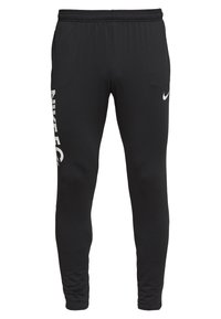 Černé sportovní kalhoty z hladkého materiálu s bílým logem Nike na levé straně a malým bílým swooshem na pravé straně.