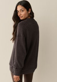 Tumehall tõmblukk-tüüpi kampsun pehmest tekstuurse kangaga. Omad ribaga kaelust ja mansette, lõdva lõikega pikad varrukad ning hubane disain.