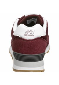 Baskets en daim marron avec col de talon blanc, semelle intermédiaire grise et semelle extérieure en caoutchouc. Caractérisées par un logo "new balance" embossé sur le talon.