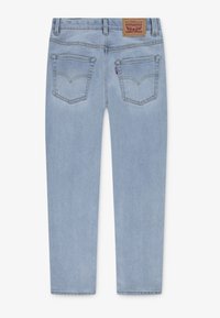 Jean en denim bleu clair vu de dos avec deux poches, passants de ceinture et un patch en cuir marron de la marque Levi's à la taille.