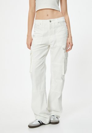 Los pantalones cargo blancos cuentan con un ajuste relajado, múltiples bolsillos laterales y una robusta tela de algodón. El diseño incluye costuras cosidas y un pequeño acento de hardware.