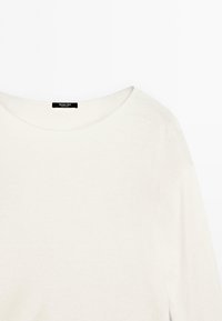 Vaalea beige neulepusero, jossa leveä, pyöreä pääntie ja pitkät hihat. Kangas näyttää pehmeältä, sileältä ja vähän yksityiskohtia sisältävältä.