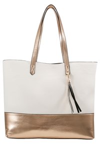Bolso tote de cuero blanco con fondo y asas en oro rosa metálico. Presenta un adorno lateral en forma de borla en negro y blanco. Textura suave.