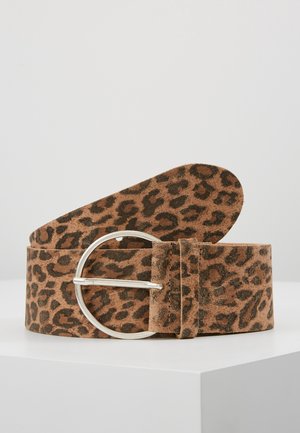 Hnědý semišový pásek s černým leopardím vzorem a kulatou stříbrnou kovovou sponou, vystavený na bílém povrchu.