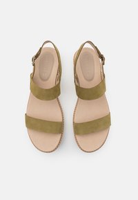 Green suede sandals with two wide straps, open back, and a cushioned beige insole. Features a stitched tan sole and adjustable buckle.