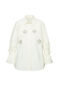 Witte button-up shirt met geborduurde diamantpatronen in zilver, voorzien van belmouwen die bij de manchetten zijn gestrikt. Gemaakt van lichte, zachte stof.