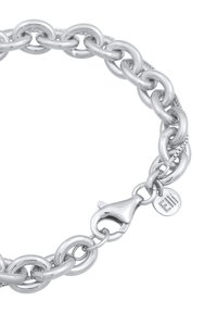 Bracciale in argento con maglie ovali interconnesse, finitura lucida e chiusura a moschettone con un piccolo tag brandizzato.