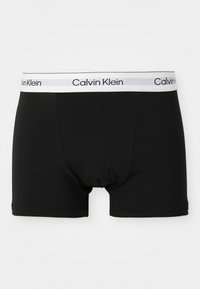 Zwarte katoenen boxershorts met een witte elastische tailleband waarop "Calvin Klein" in het zwart is gedrukt. Glad materiaal en een aansluitend ontwerp.