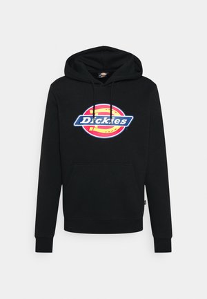 Sudadera negra de algodón, con un bolsillo frontal y cordones. Presenta un colorido logo circular con "Dickies" en letras negritas.