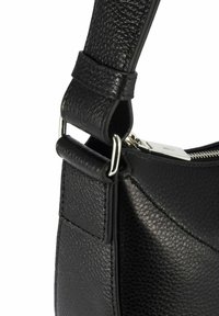 Róg czarnej torby skórzanej o teksturowanej powierzchni, z poduszkowanym paskiem przymocowanym srebrnymi metalowymi pierścieniami i widocznym srebrnym suwakiem.