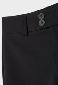 Pantalon noir présentant une texture lisse, une coupe droite et deux boutons noirs à la taille pour la fermeture.