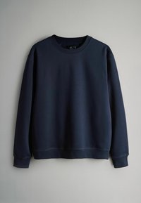 Jūras zila džemperis, izgatavots no mīkstas auduma, ar apaļu kakla izgriezumu, garām piedurknēm un ribotām aprocēm un apakšmalu. Vienkāršs, minimāls dizains.