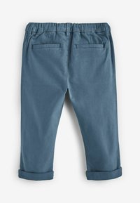 Blaue Baumwollhose mit elastischem Bund, umgeschlagenen Säumen und zwei Gesäßtaschen. Glatte Textur und gerader Schnitt.