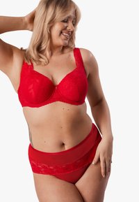Czerwony koronkowy biustonosz z usztywnianymi miseczkami i kwiatowym wzorem, zestawiony z czerwonymi majtkami z wysokim stanem, wykonanymi z przezroczystej siateczki z koronkowymi brzegami.