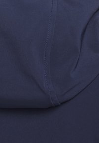 Tissu bleu foncé avec coutures visibles et plis subtils créant texture et forme.